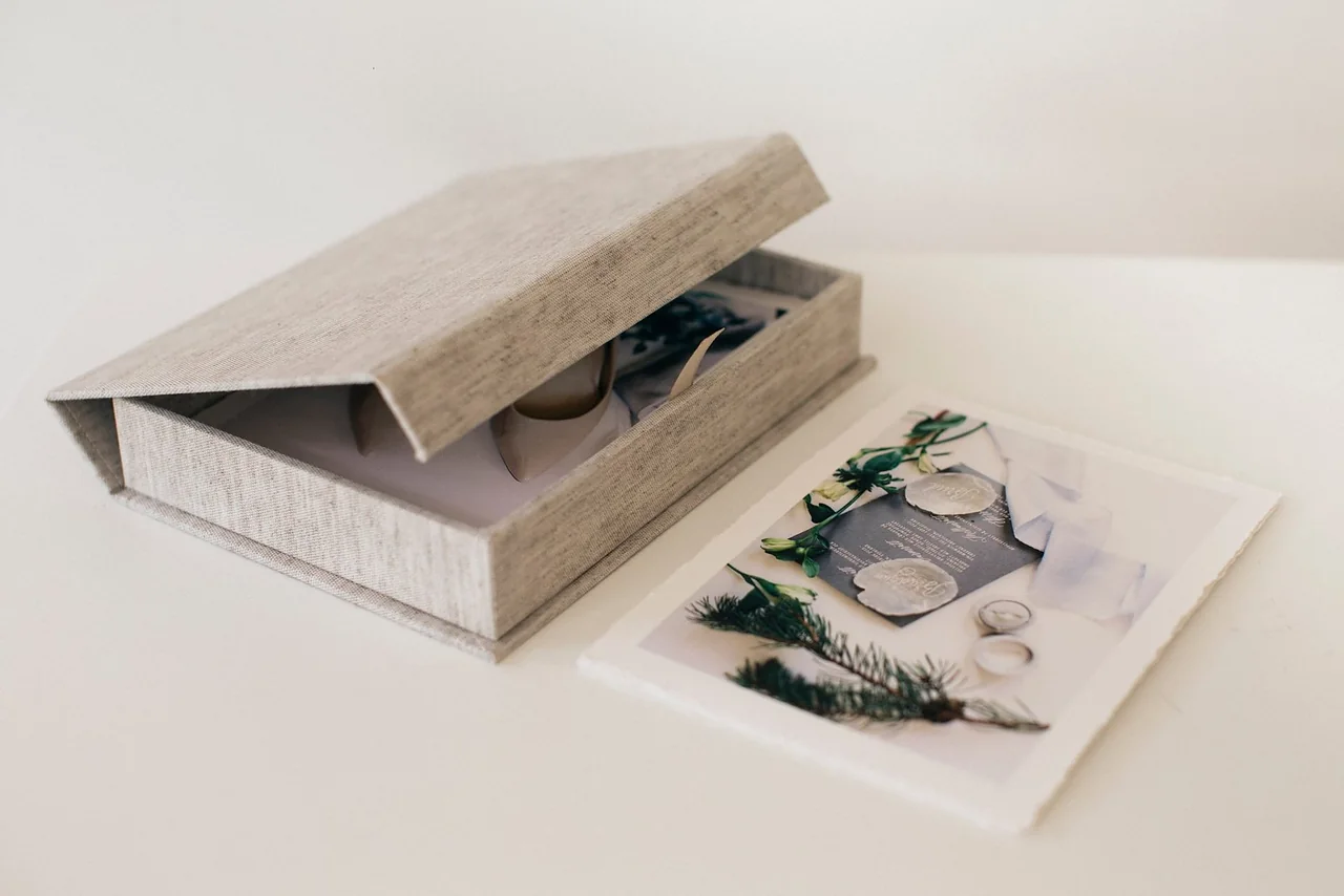 A linen clamshell box opened to show prints inside