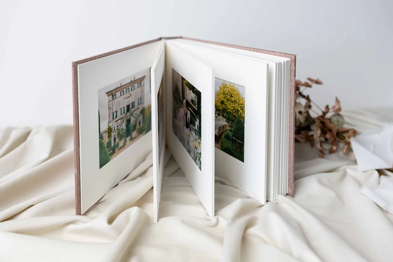 An open matted album standing upright, one photograph to a page