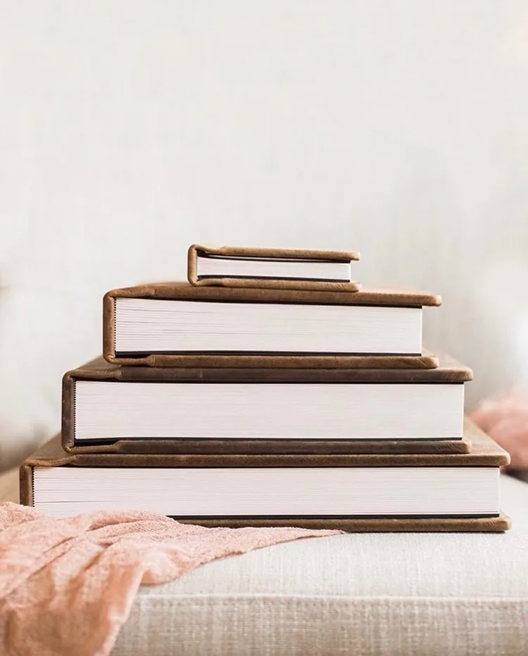 Three matching albums in descending sizes stacked on a bed