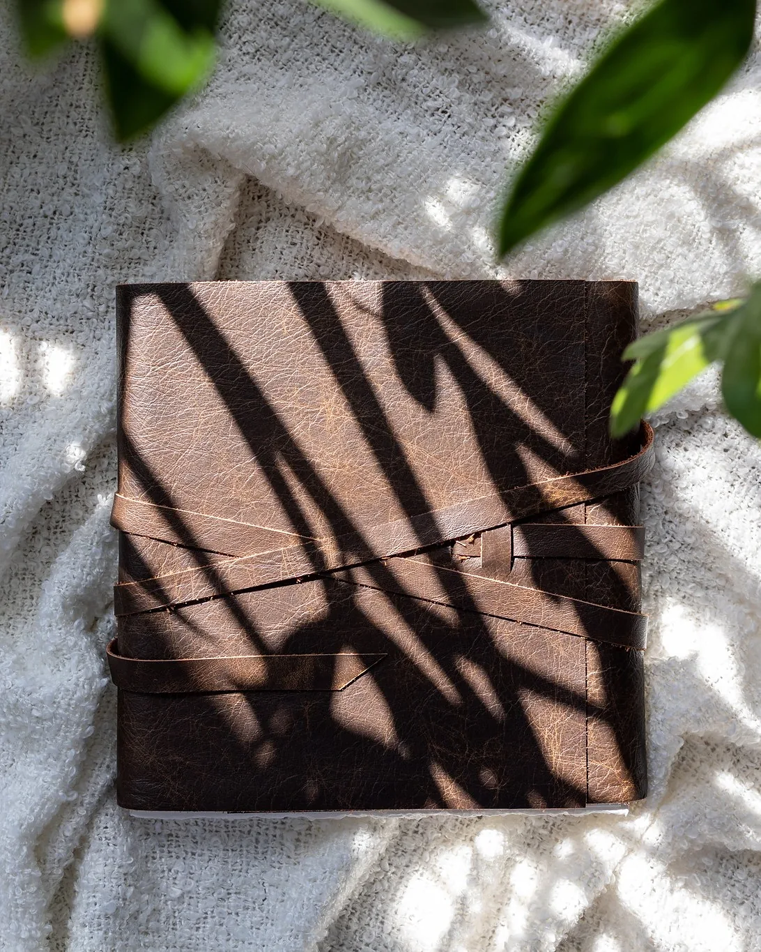 A closed suede album with a leather tie and no title on the cover